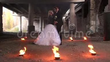 一对夫妇穿着万圣节婚纱的肖像，在他们周围燃烧。